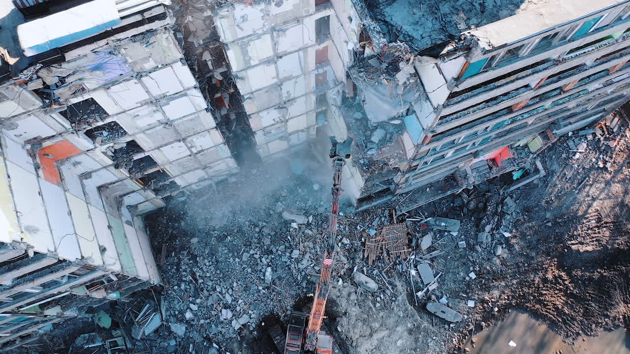 Construction of destroyed house. Destructive demolition building by excavator.