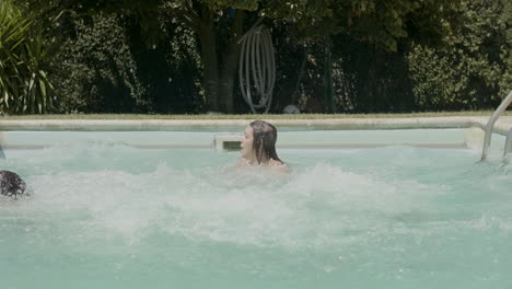 cheerful parents and kids running into swimming pools together