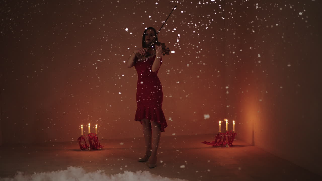 Violinista in abito rosso che suona in un paesaggio invernale incantato