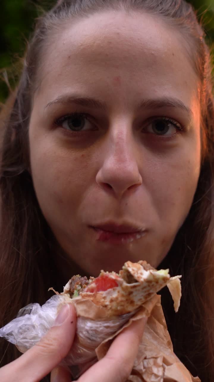 Urban food scene in Sofia Bulgaria as a woman enjoys her lunch with a handheld falafel wrap in a casual setting