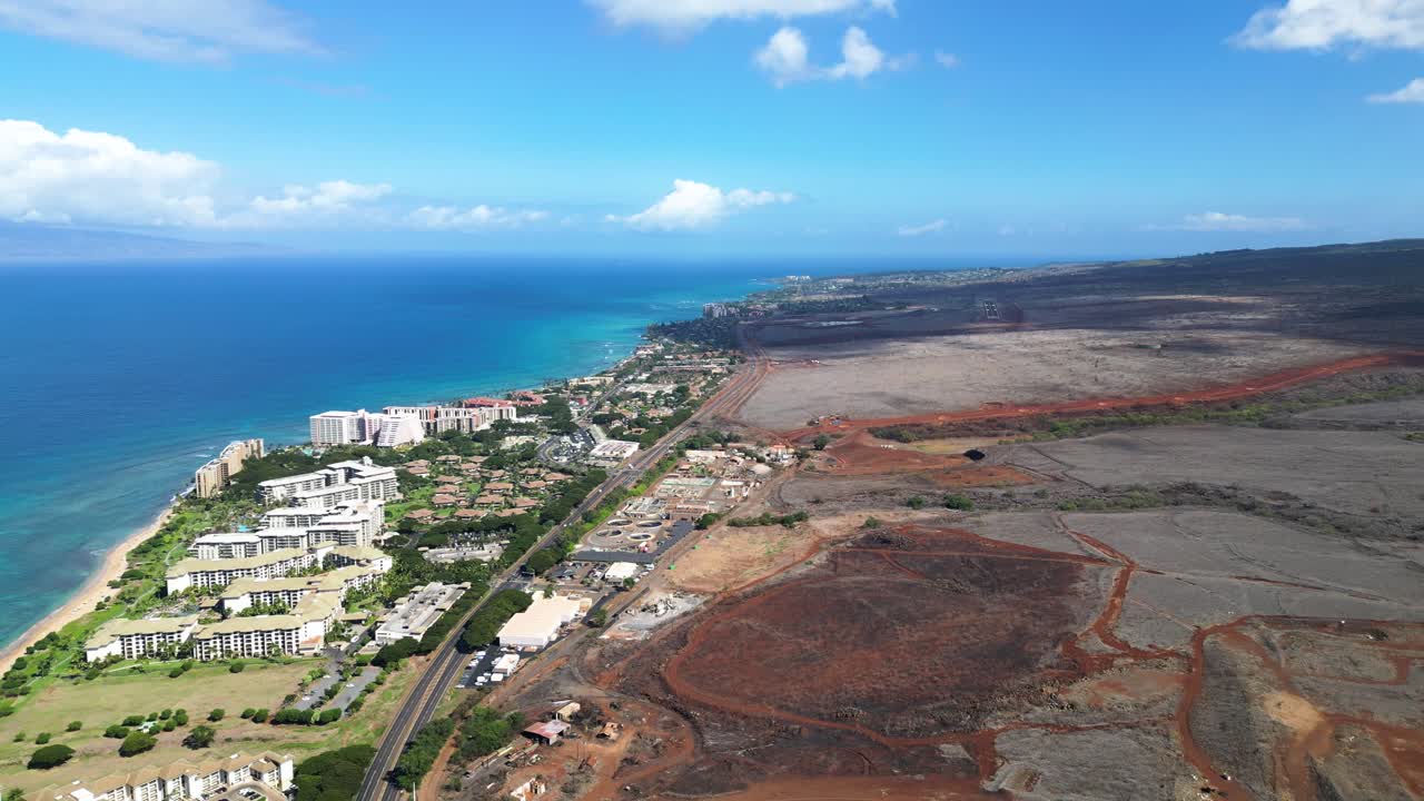 High drone view shows luxury shoreline hotels, main road, and burned arid land