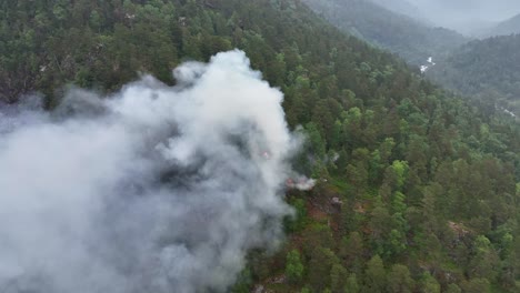 Devastating-forest-fire-due-to-dry-forest-and-global-warming---Newly-started-fire-in-mountains-of-Norway---Aerial-showing-fire-and-rotating-around-smoke