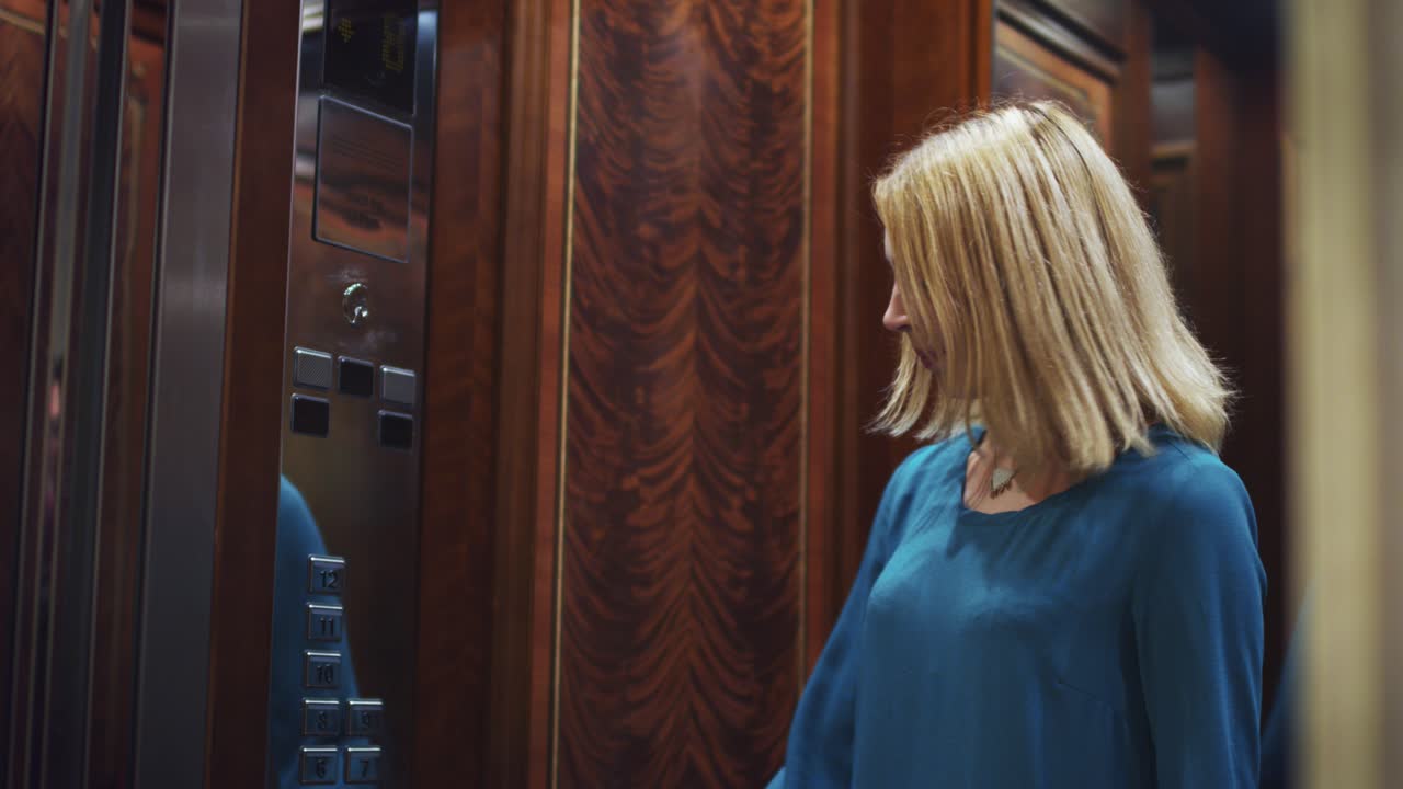 открытие зеркальных дверей лифта и молодая женщина, входящая в лифт