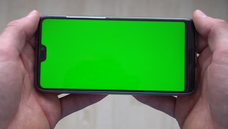 Una-Persona-Sosteniendo-Un-Teléfono-Con-Una-Pantalla-Verde