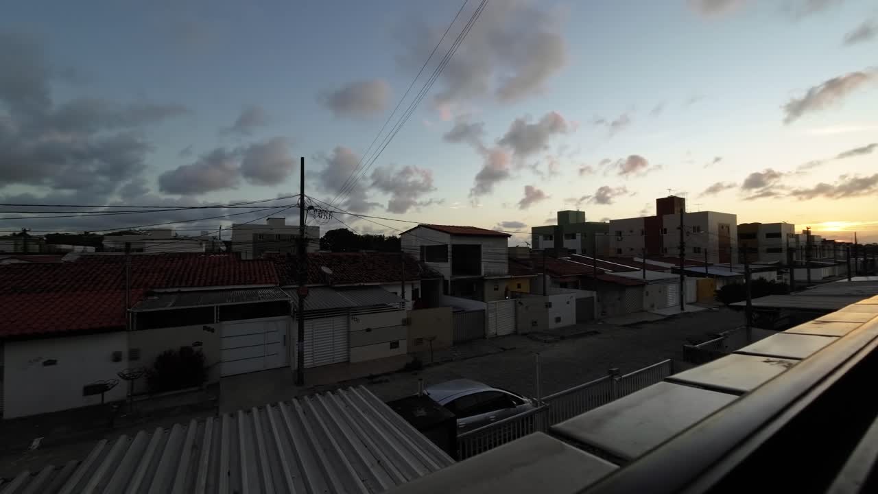 lapso de tiempo del atardecer desde la ventana de un pequeño apartamento mirando a la comunidad pobre de valentina en la capital de la playa joao pessoa en paraiba, brasil en una cálida tarde de verano