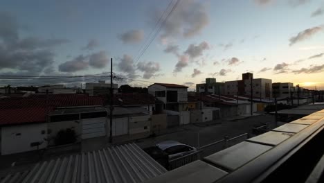 Sunset-Time-lapse-from-the-window-of-a-small-apartment-looking-out-at-the-poor-community-of-Valentina-in-the-beach-capital-Joao-Pessoa-in-Paraiba,-Brazil-on-a-warm-summer-evening
