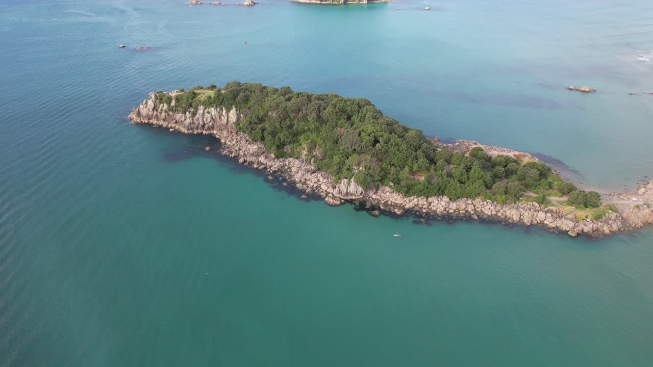 Aerial View of a Small Island with Rocky Coastline and Turquoise Ocean