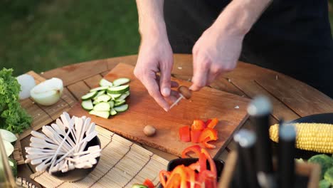 young man preparing vegetable skewers for grilling high angle