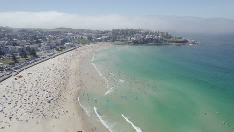 Niebla-Espesa-Vista-Desde-La-Bulliciosa-Playa-De-Bondi-En-Nueva-Gales-Del-Sur,-Australia,-Mientras-Las-Multitudes-Se-Reúnen-En-La-Orilla