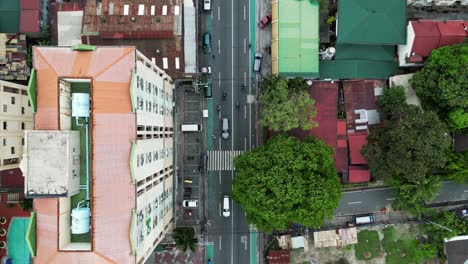 drone top down perspective of quezon city bustling street, apartment buildings homes