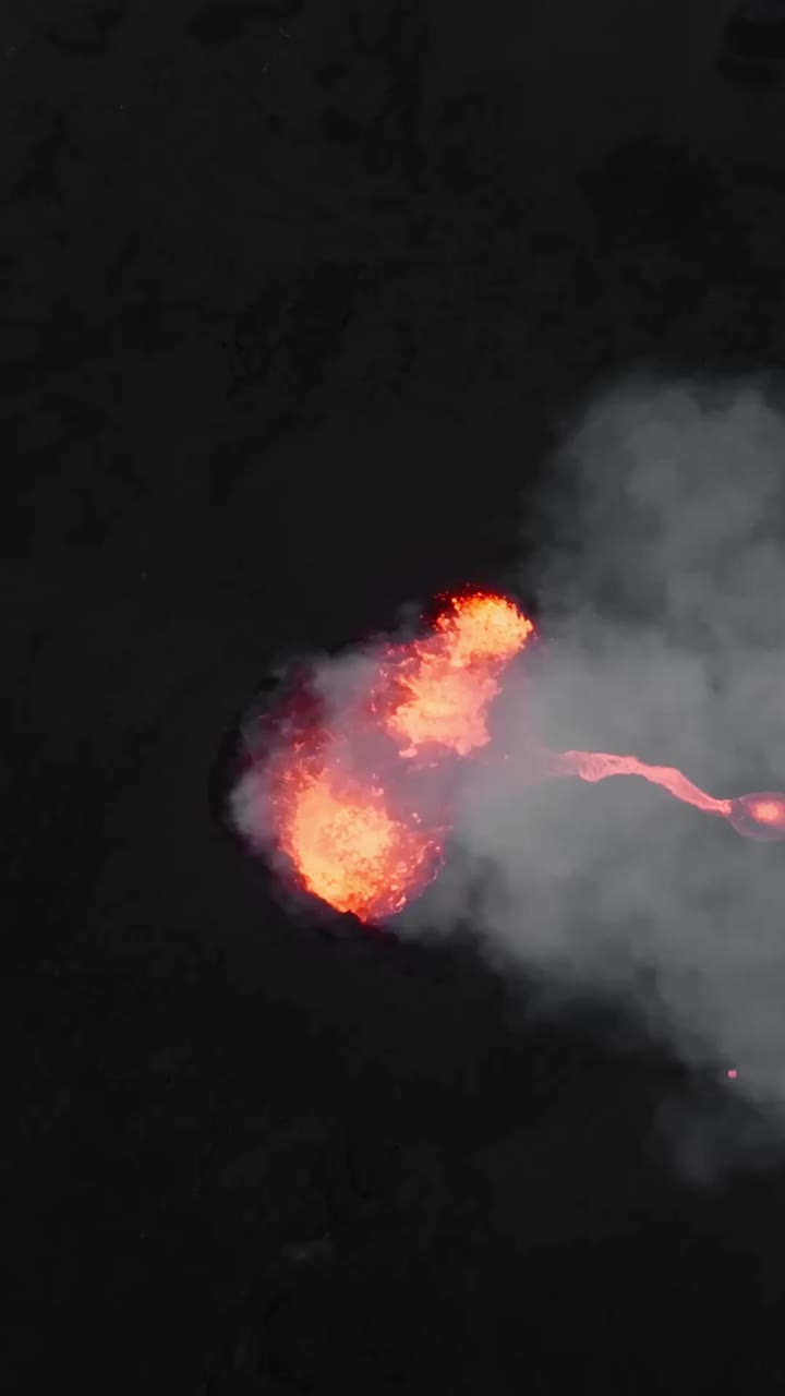 Aerial drone overview of volcanic landscape with glowing lava and thick layer of smoke