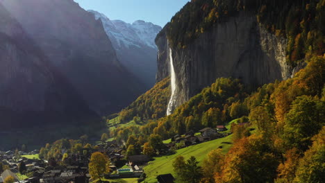 toma aérea cinematográfica de una cascada y un pueblo de staubbach en lauterbrunnen, suiza