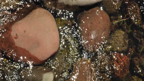 water flowing through large stones in a lake