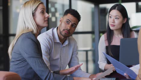 Video-of-caucasian-businesswoman-talking-to-diverse-colleagues-at-office-meeting