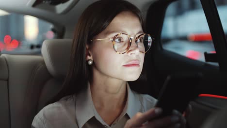 beautiful woman using smartphone while riding in taxi