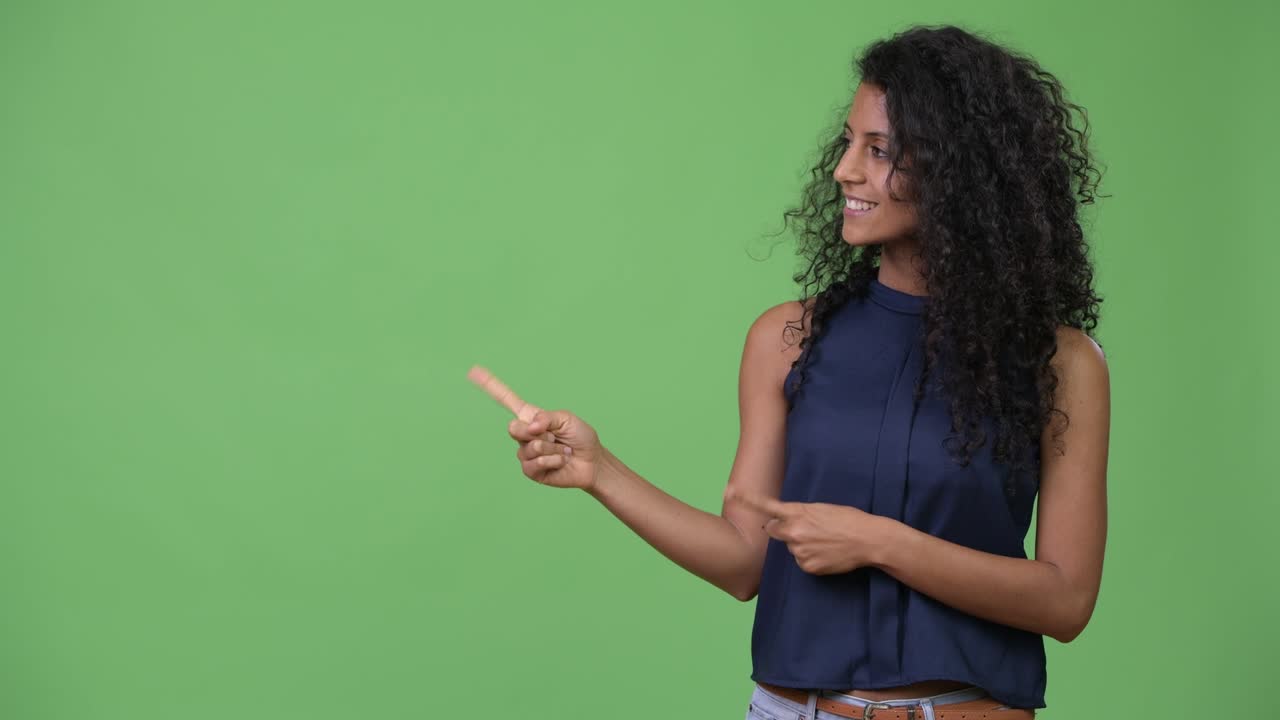 Young beautiful Hispanic businesswoman showing something