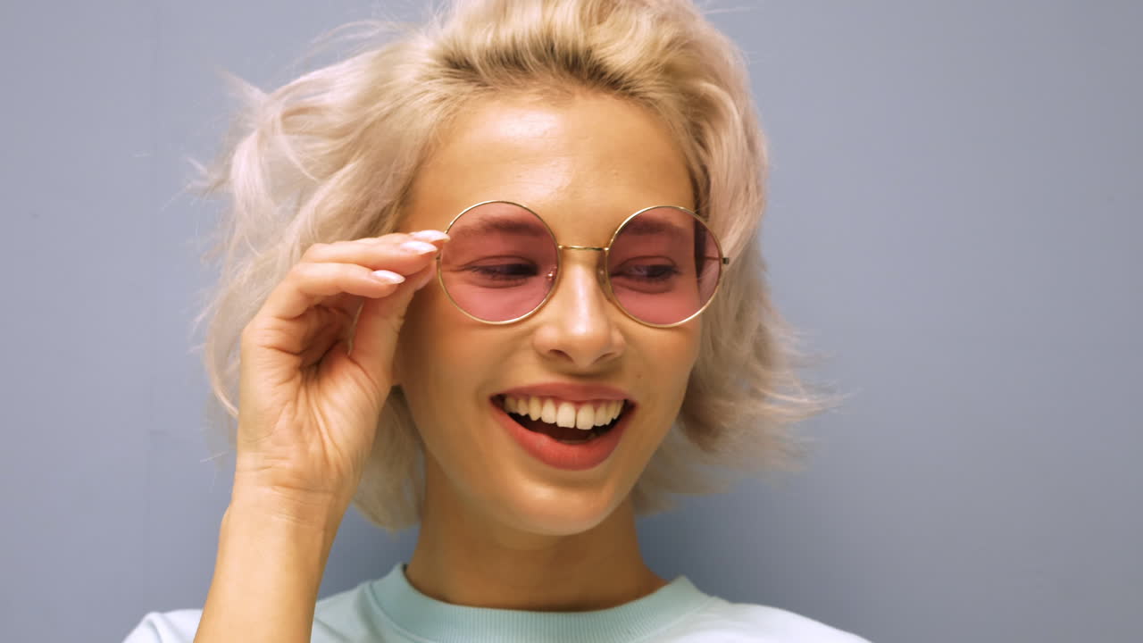 mujer sonriente con gafas rosadas