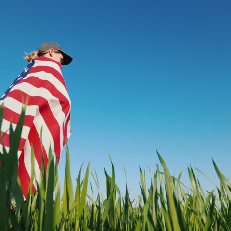 A-Farmer-With-A-Usa-Flag-Stands-In-A-Field