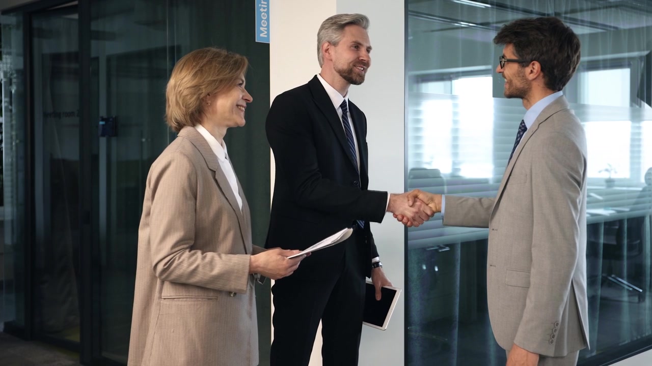 Professionisti d'affari che si stringono la mano e parlano in un ufficio moderno