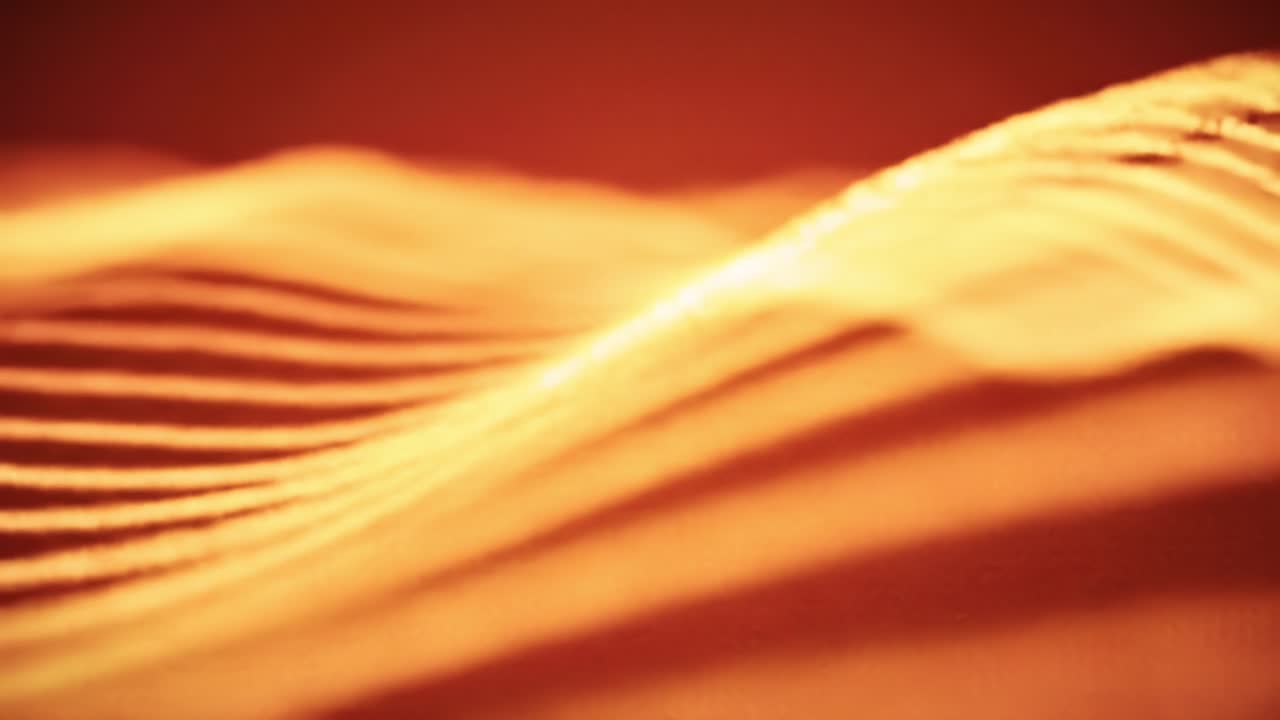 Experiencing mesmerizing patterns and textures as warm light cascades and dances, creating a vibrant display of color and movement in an abstract setting.