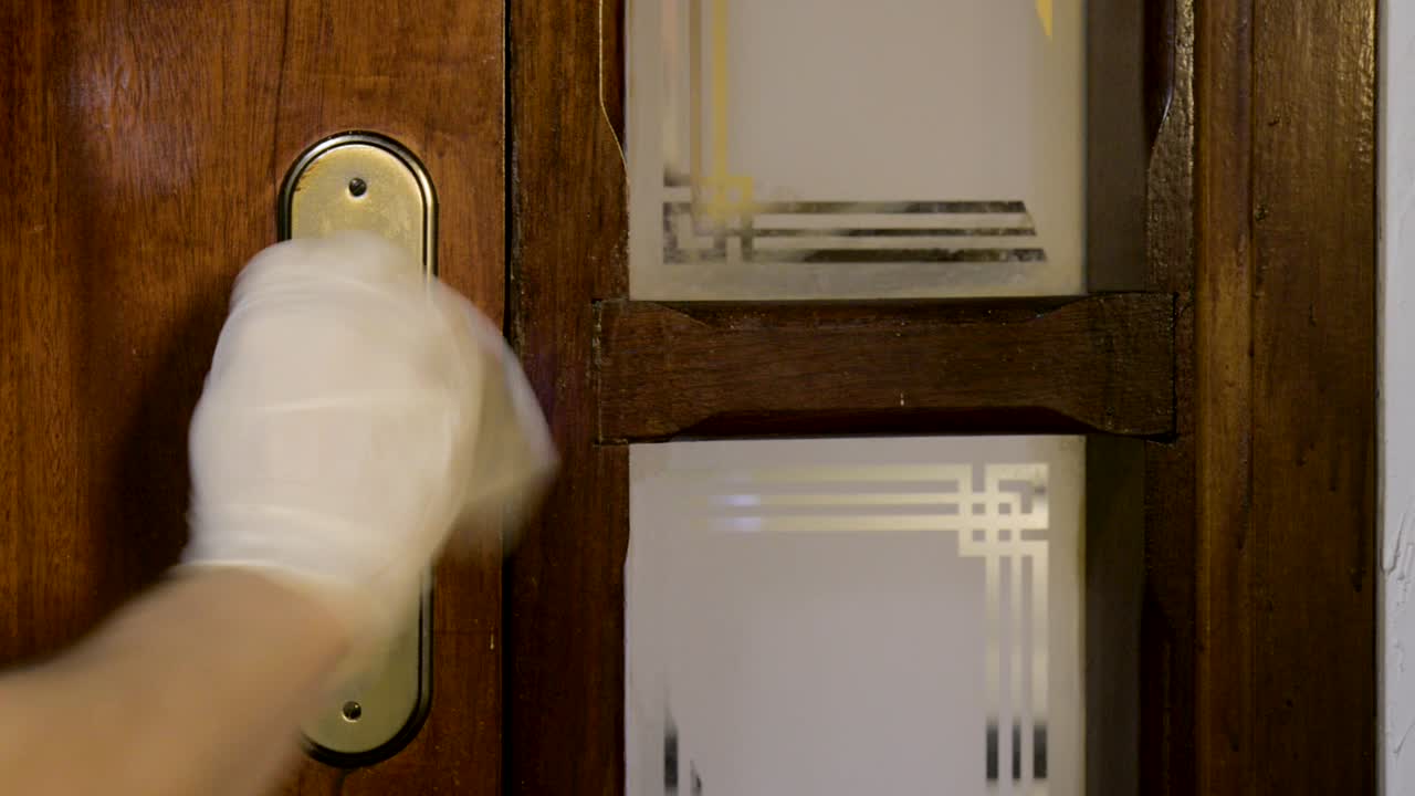 prevención del coronavirus covid-19 limpieza hombre limpieza del mango de la puerta con toallita desinfectante antibacteriana para matar el virus corona en el manillar de la puerta