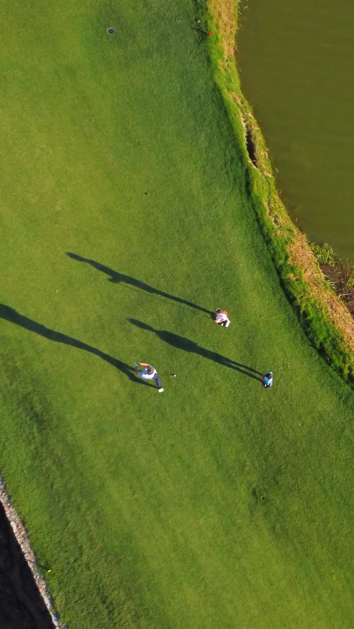 Aerial view of golfers on a green golf course