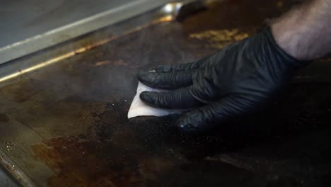 putting a slice of fish onto the hot cooking stove in slow motion