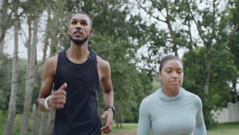 two fit people running in a park