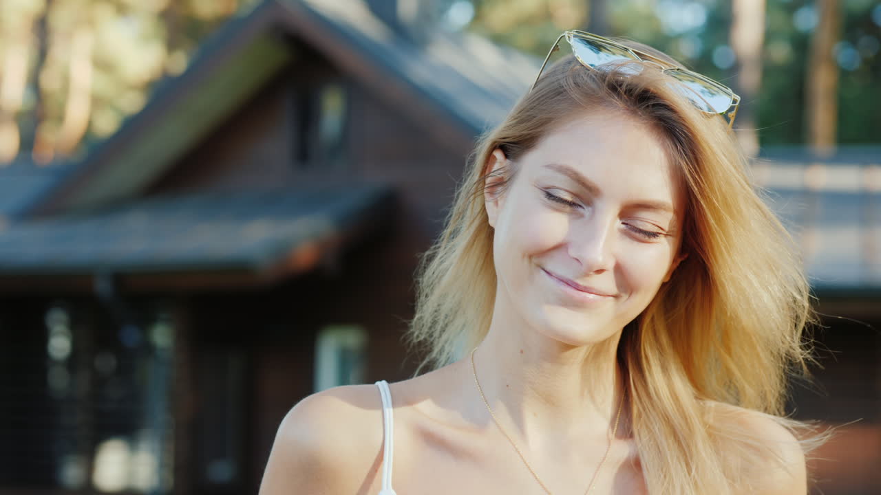 Portrait Of A Young Attractive Woman On The Background Of Her House