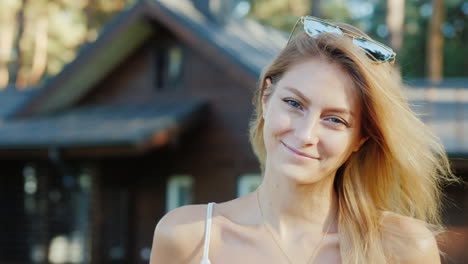 portrait of a young attractive woman on the background of her house