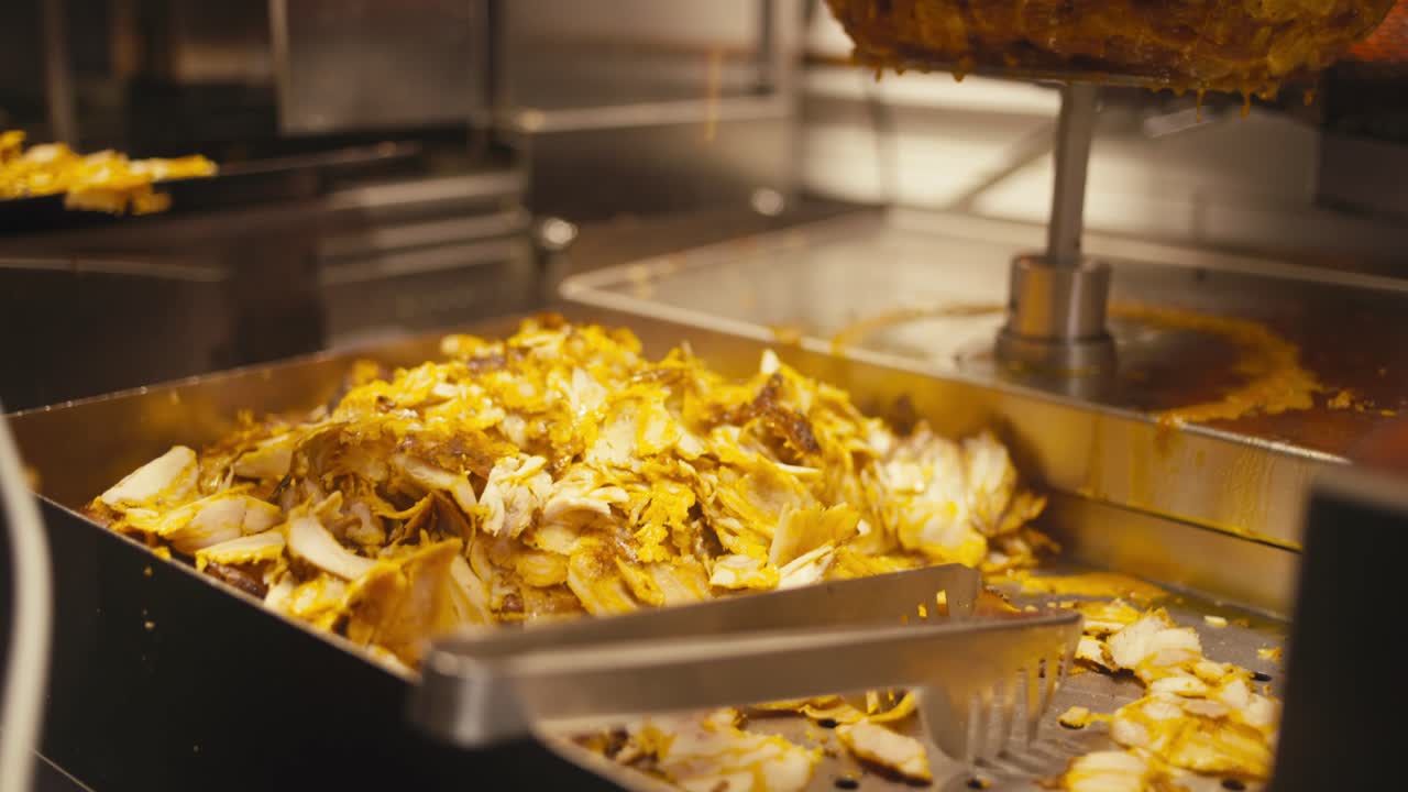 가게에서 황금 케바브 고기를 잘라내는 모습, 근접 시각, 따뜻한 조명