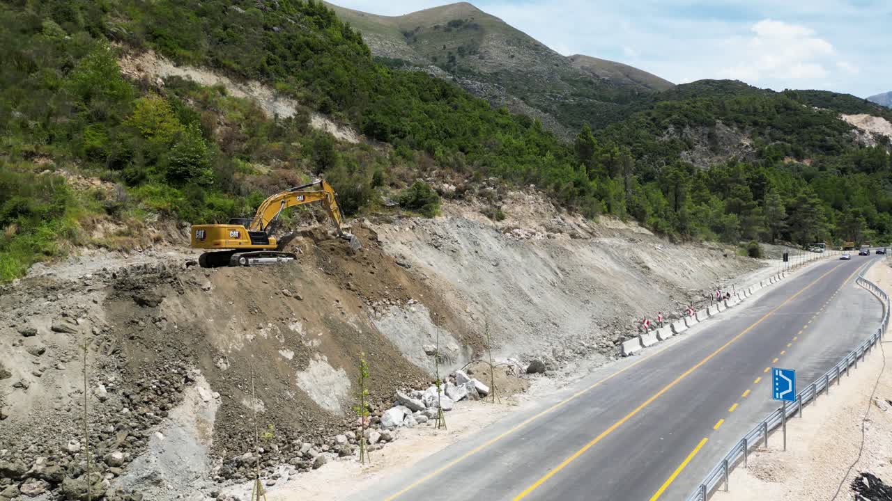 excavadora que despeja el camino para una nueva carretera en caminos de montaña