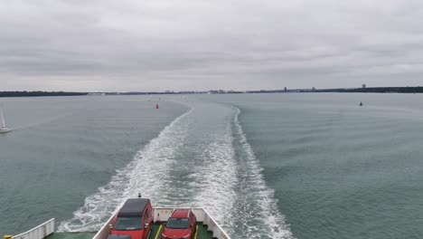 ferry rápido del canal que va de southampton a east cowes, muchos barcos pasan por la toma en un día muy nublado y sombrío y el barco se estrella contra las olas