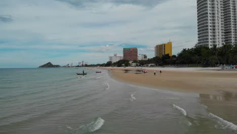 hua hin beach thailand with condominiums, boats and beach activities, aerial flyover