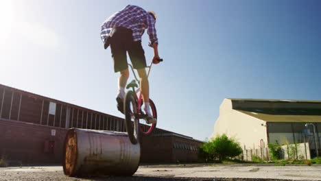 bmx rider doing trick in an empty yard