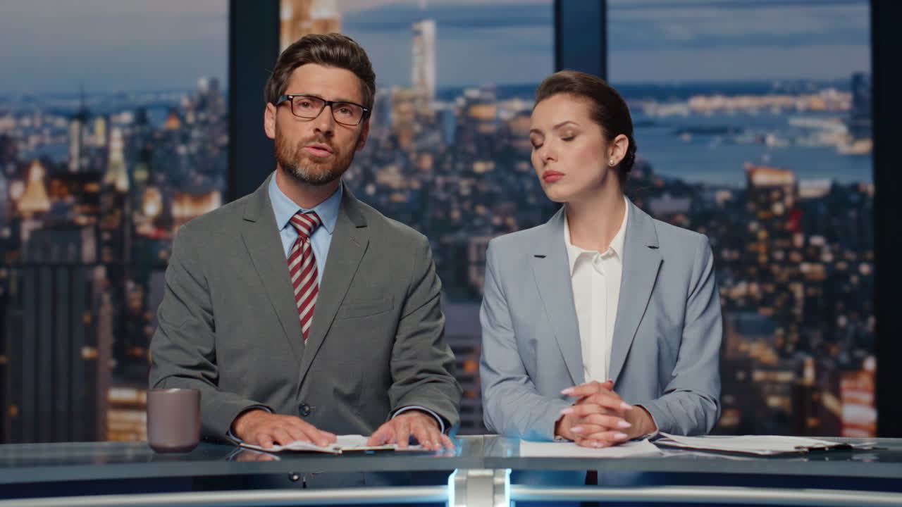 los lectores de noticias confiados terminan las noticias de la noche en el primer plano de la tv. los presentadores se despiden