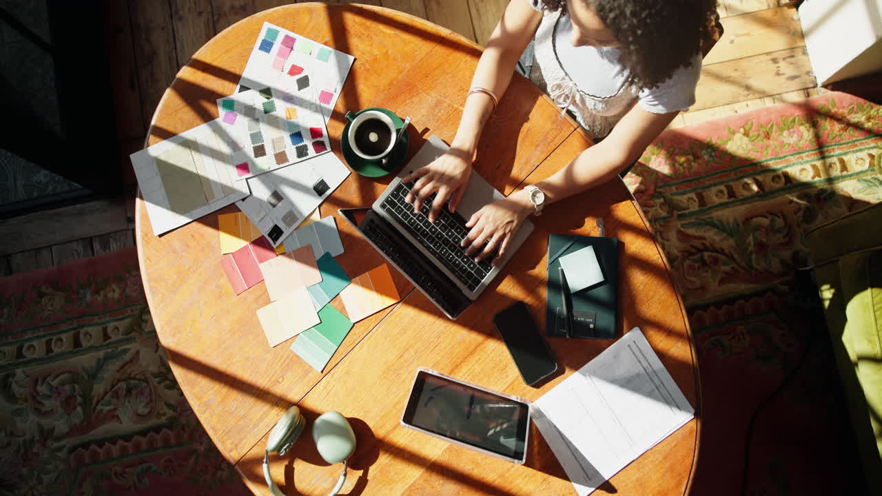 Woman Working on Laptop with Color Swatches in Home Office