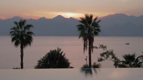 Eine-Offene-Schwimmbadgrenze-Und-Ein-Abendlicher-Meerblick-Vor-Den-Bergen