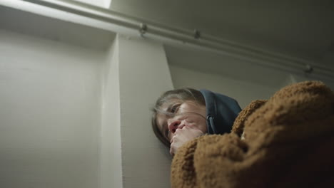 close-up shot of a tearful girl leaning against the wall of an underpass tunnel. she appears deeply troubled, with her hand partially covering her face, a moment of emotional distress