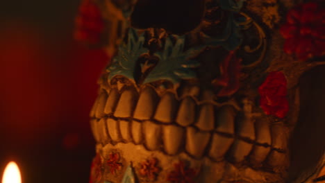 close up on still life of decorated skulls lit by candles celebrating mexican holiday of dia de muertos or day of the dead 11