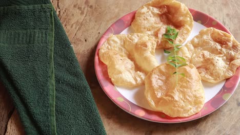 chole bhature o curry de garbanzos y puri frito servido en vajilla de terracota sobre fondo de madera