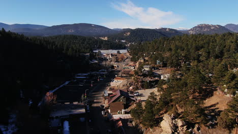 Aerial-Cinematic-drone-fly-over-Downtown-Evergreen-and-ice-skating-lake-in-Colorado-forward-movement-mid-winter-no-snow