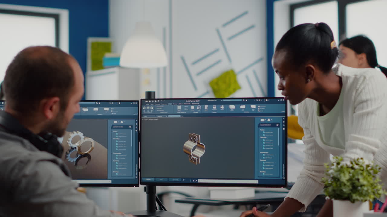 Multiethnic team sharing ideas about industrial project using dual displays setup