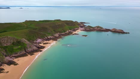 aerial drone view of the idyllic plage de lourtuais beach, the rocky peninsula of cap d'erquy, and calm turquoise sea in brittany, france