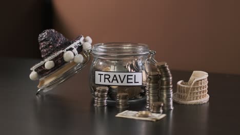 hombre pone monedas en el vidrio con inscripción viaje