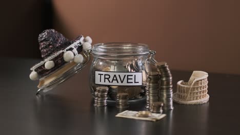 man puts coins into glass with inscription travel