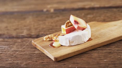 queso cubierto de nuez, frutas y salsa