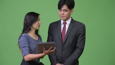 young handsome asian businessman and young asian woman working together