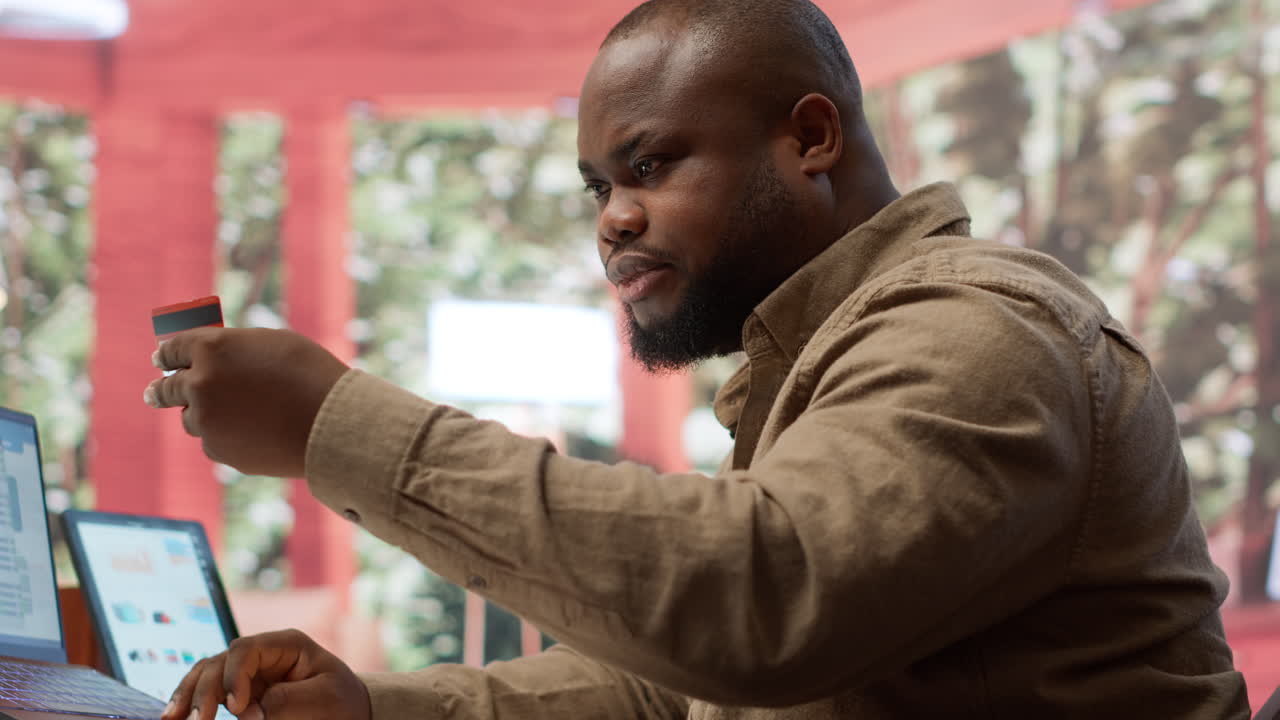 empresario que utiliza una tarjeta para hacer un pago de compras en línea