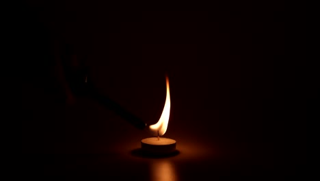 a single candle burning and flickering in the dark